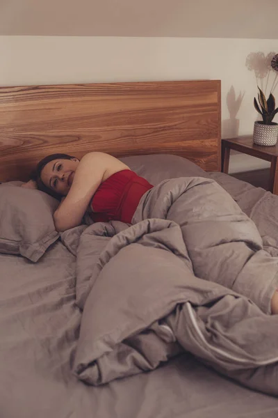 Beautiful girl in red pajama sleeping in bed — Stock fotografie