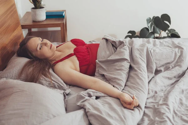 美しいです女の子で赤pajama睡眠でベッド — ストック写真