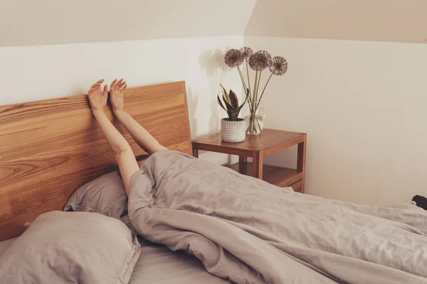 Overdekte vrouw met uitstekende handen uit deken — Stockfoto