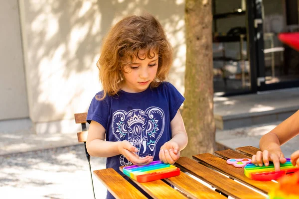 カラフルなストレス玩具フィジェットは子供の手でそれをプッシュ — ストック写真