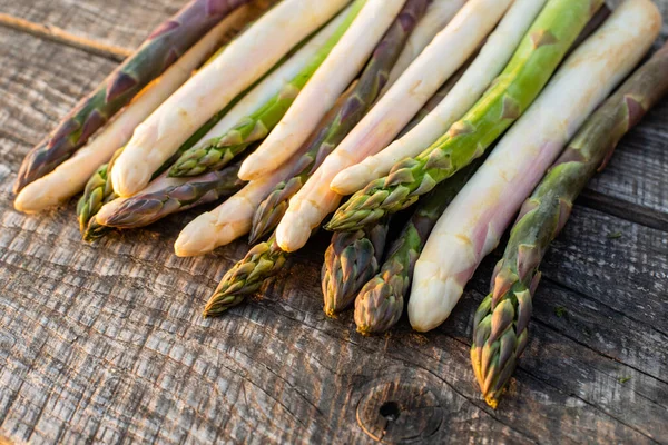 White, purple and green asparagus on wooden table — Stock Photo, Image