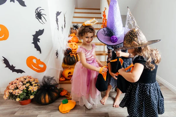 Meninas recebendo um monte de doces durante halloween truque ou tratamento — Fotografia de Stock