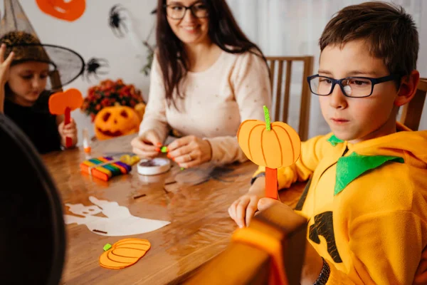 Lindo chico en traje de calabaza demuestra su calabaza de papel hecha a mano — Foto de Stock