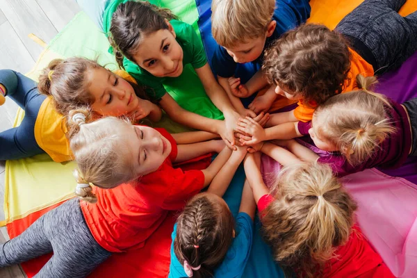 Glückliche Kinder liegen im Kreis auf dem Boden — Stockfoto