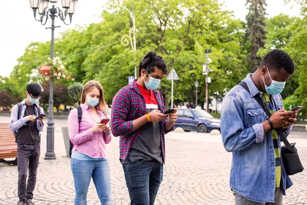 La gente con máscaras hace cola para mantener la distancia social — Foto de Stock