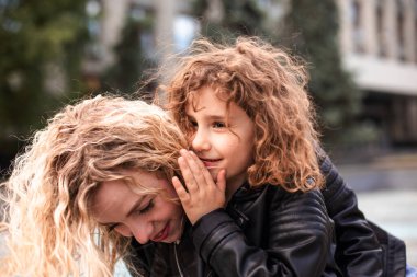Anne ve kızı şehirde dolaşırken fısıldıyorlar.