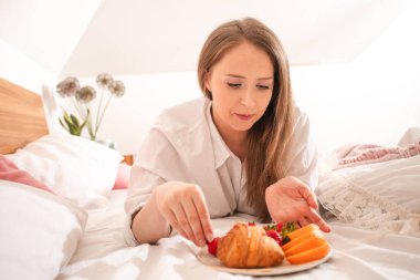 Yakından bir kadının elinde tatlı bir çilek var.