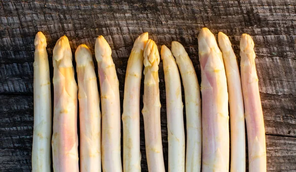 Asperges blanches crues sur la table en bois — Photo