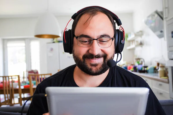 Volwassen jongeman in headset spreken door webcam — Stockfoto