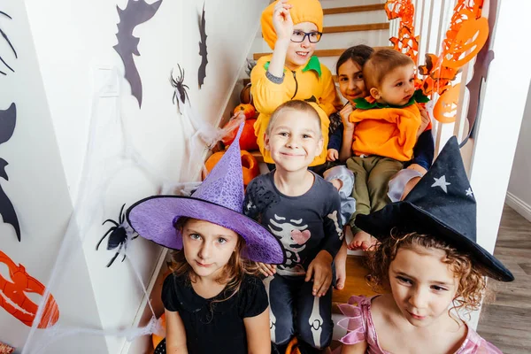 Festa de férias de Halloween para crianças. Crianças disfarçadas em escadaria — Fotografia de Stock