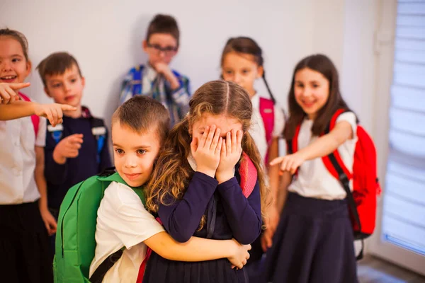 De dappere kleine schooljongen beschermt een schoolmeisje tijdens het pesten — Stockfoto