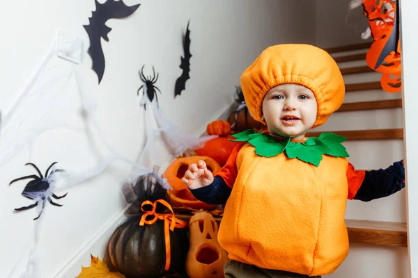 Carino sorridente bambino vestito da zucca guardando la fotocamera — Foto Stock