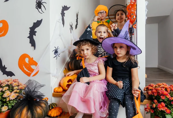 Halloween holiday party for children. Kids in costumes on staircase — Stock Photo, Image