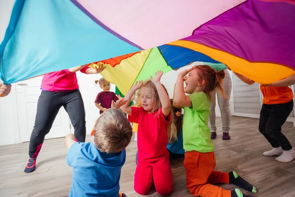 Nahaufnahme von Kindern unter einer riesigen Regenbogendecke — Stockfoto