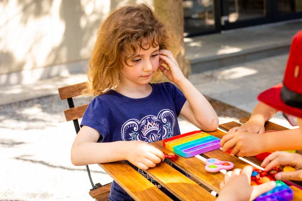 Coloré jouet anti-stress violon pousser pop il dans les mains des enfants — Photo