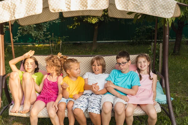 Lustige Kinder ruhen sich auf großer Gartenschaukel aus — Stockfoto