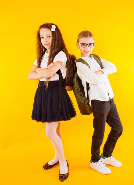 De kleine schoolkinderen kijken elkaar aan. — Stockfoto