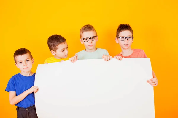 The different little boys are holding a big white paper — Stock Photo, Image