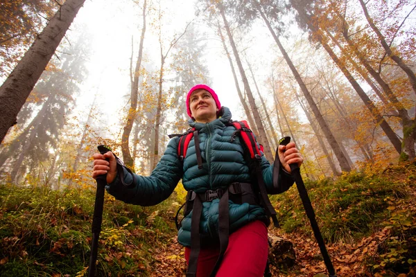 Happy woman hiker is walking in the beautiful autumn forest — Stock fotografie