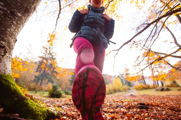 Kobieta turysta kroki na kamerze w jesiennym lesie — Zdjęcie stockowe