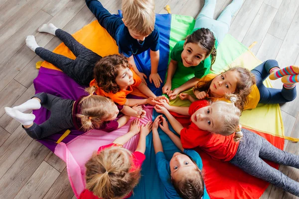 Gelukkige kinderen liggend op een vloer in een cirkel — Stockfoto