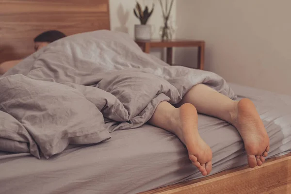 Voeten van een vrouw die thuis in bed slaapt — Stockfoto