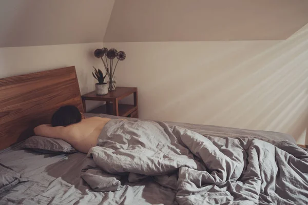 Stralen van de ochtendzon schijnt op jonge slapende vrouw — Stockfoto
