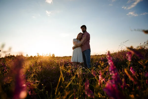 Casal romântico amor momento no campo entre flores selvagens — Fotografia de Stock