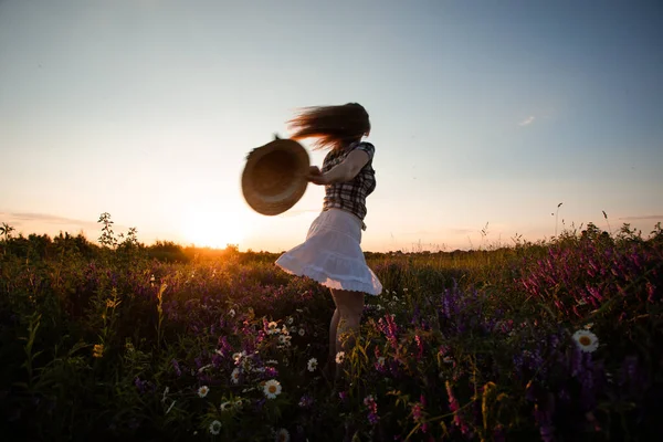 Fröhliche und verspielte junge Frau läuft im Sommerfeld — Stockfoto