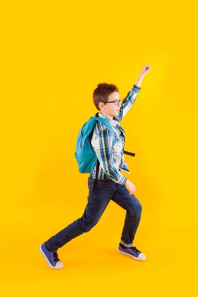 Springen emotionele schooljongen op de gele achtergrond — Stockfoto