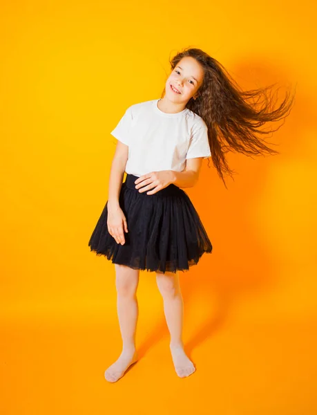 Щаслива дівчинка стрибає на жовтому тлі — стокове фото