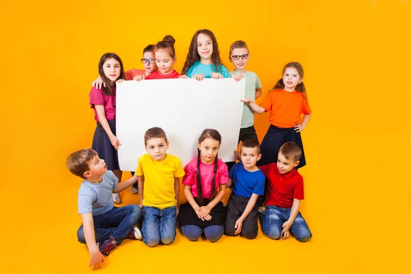 The group of kids holding a big white copy space poster