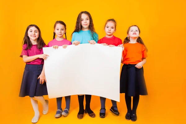 Os meninos diferentes estão segurando um grande livro branco — Fotografia de Stock