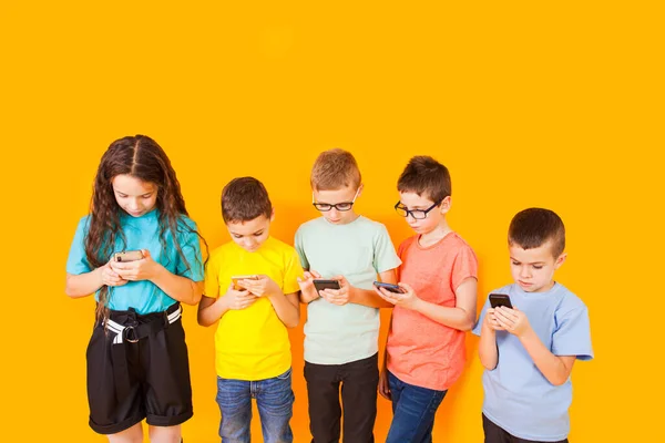 Grupo de niños usando teléfono móvil digital — Foto de Stock