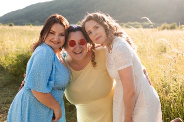 Mutlu kız arkadaşlar doğada sarılıyorlar.