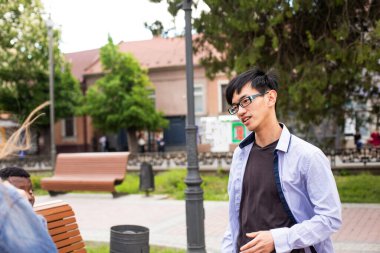 Şehir parkındaki Asyalı genç adam.