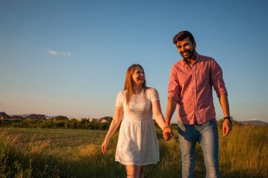 Yaz tarlasında yürüyen sevimli bir çift