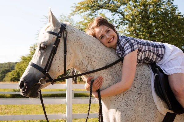 De jonge vrouw brengt tijd door met haar favoriete paard — Stockfoto