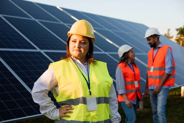 Женщина-инженер с избыточным весом позирует на солнечной станции — стоковое фото