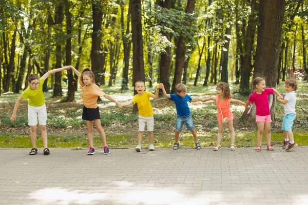 Bambini del campo estivo che fanno onda, tenendosi per mano insieme — Foto Stock