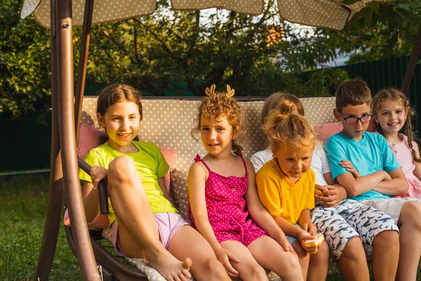 Bambini divertenti che riposano su grandi altalene da giardino — Foto Stock