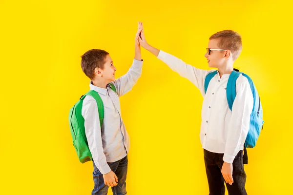 Springen emotionele schooljongens op de gele achtergrond — Stockfoto