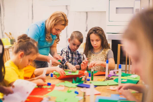 Przedszkolaki składają aplikację pod nadzorem pedagoga — Zdjęcie stockowe