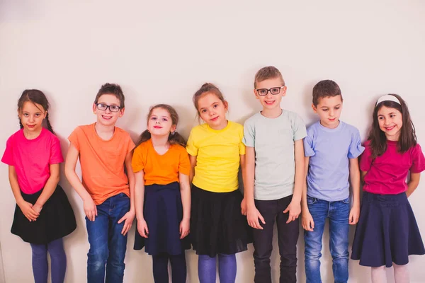 Kinder in bunten Schuluniformen auf weißem Hintergrund — Stockfoto