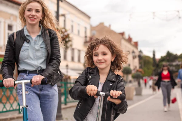 Het stijlvolle meisje rijdt op een scooter in de stad — Stockfoto