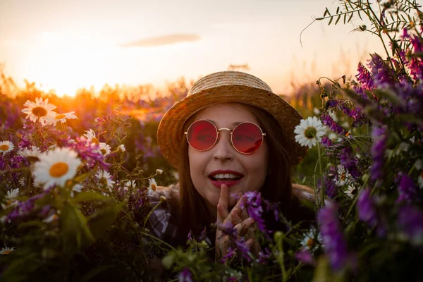 Artystyczny portret kobiety w czerwonych okularach wśród kwiatów — Zdjęcie stockowe
