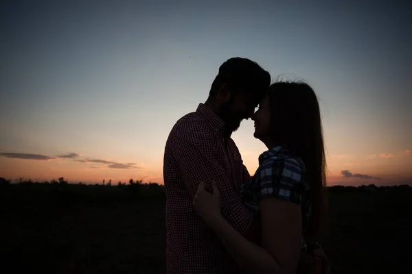 Abraçando casal em raios de pôr do sol — Fotografia de Stock