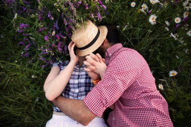 Yaz tarlasında çiçek açan romantik bir çift.