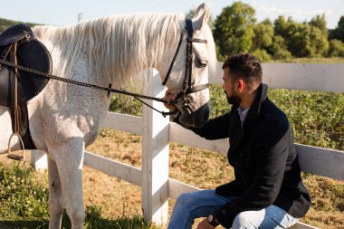 Adam çiftlikte bir atla dinleniyor.