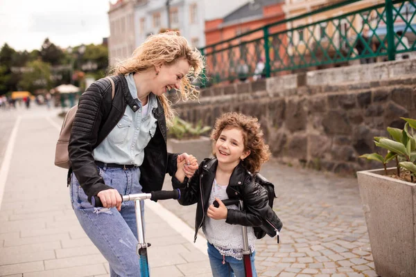 Identyczna mama i córka ze skuterami w mieście — Zdjęcie stockowe